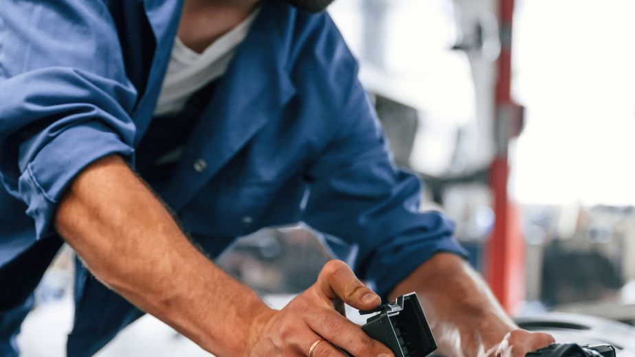 Mechanic working on a car engine in an auto shop