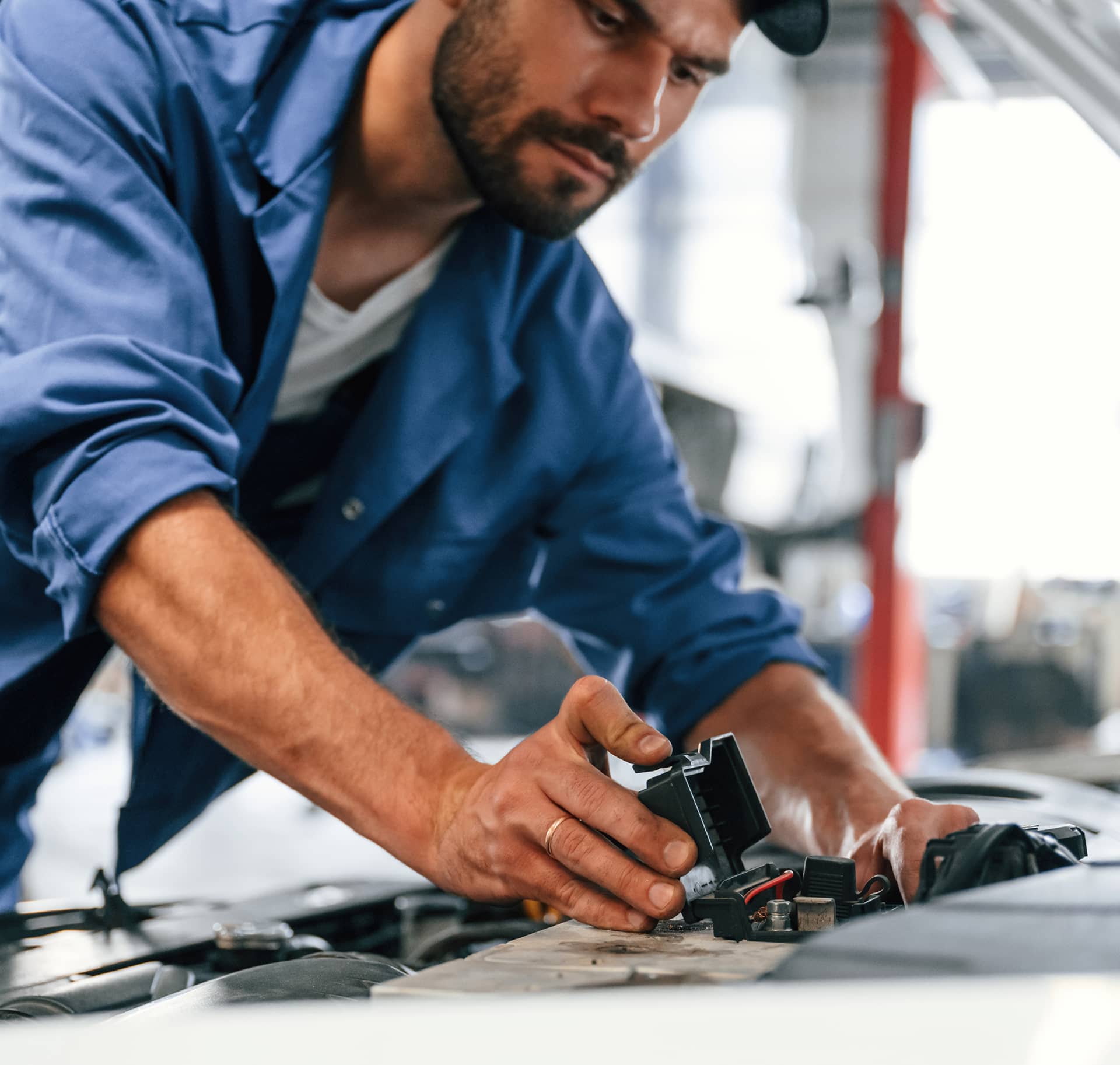 Mechanic working on a car engine in an auto shop