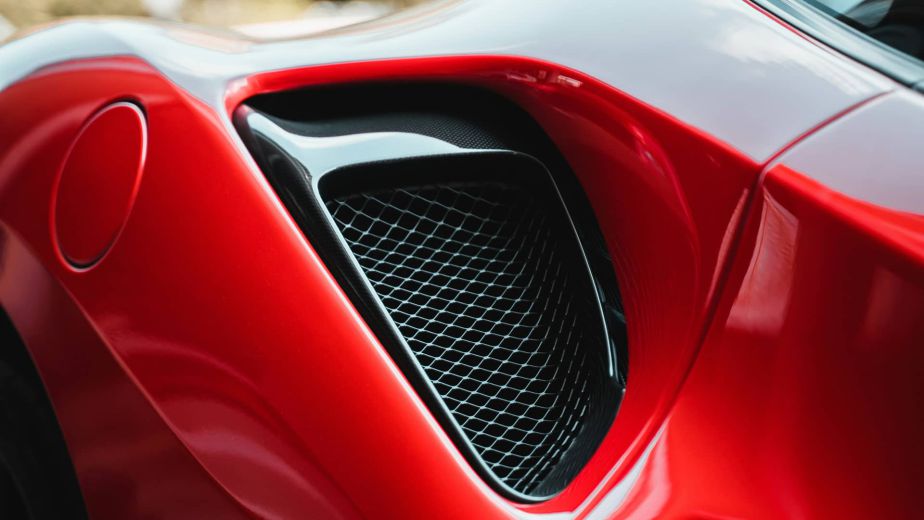 Close-up of a red sports car's side air vent