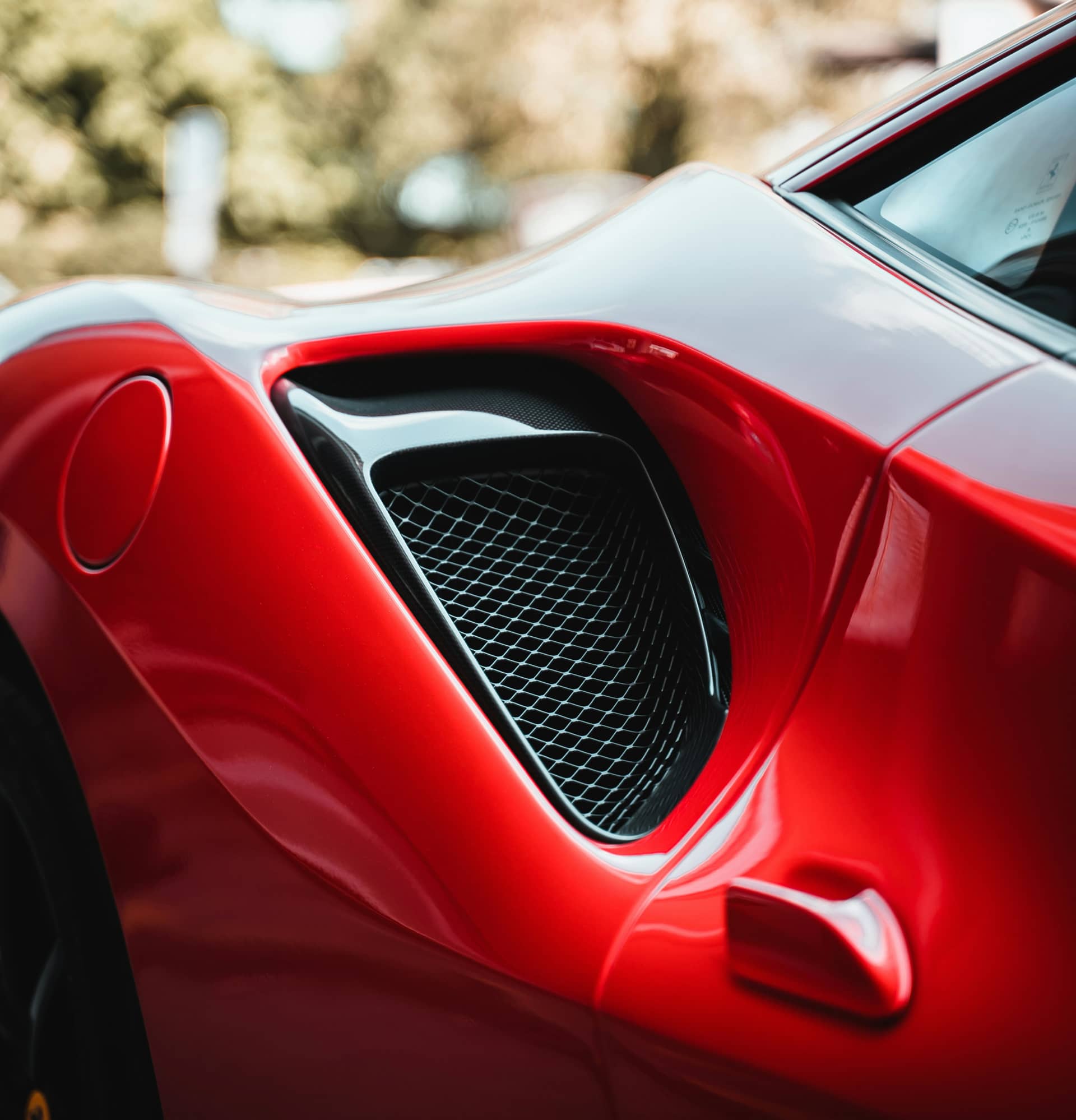 Close-up of a red sports car's side air vent